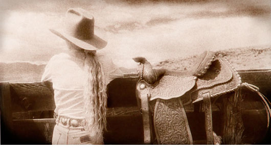 Cowgirl and Saddle on fendce